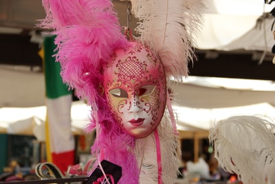 粉红色和白色的羽毛面具
